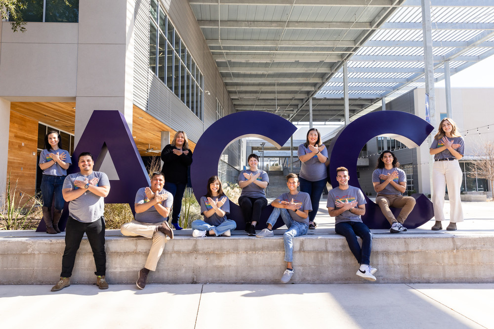 ACC recruitment team posing next to Giant ACC letters. 